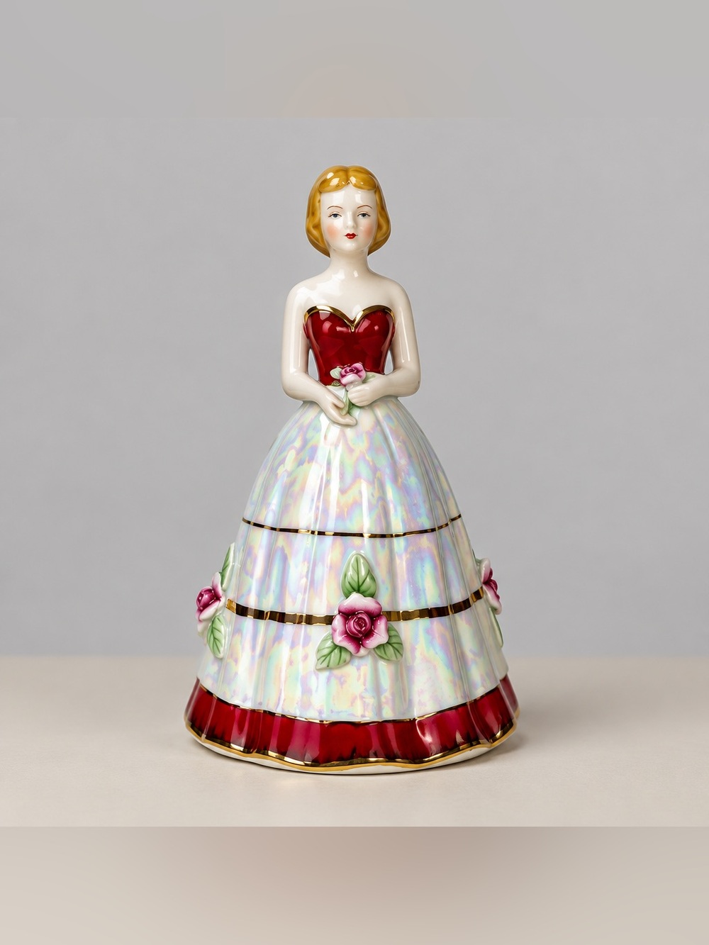 Porcelain Victorian style figurine dressed in an opalescent red and white Dress